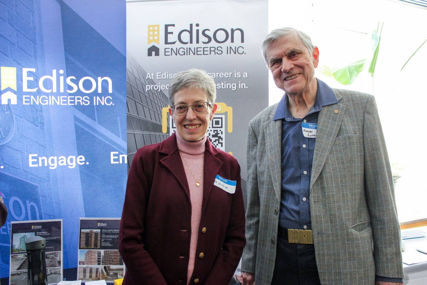 man and woman standing in front of a trade show booth