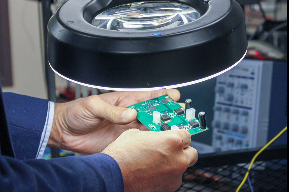 smiling woman in lab with glowing samples
