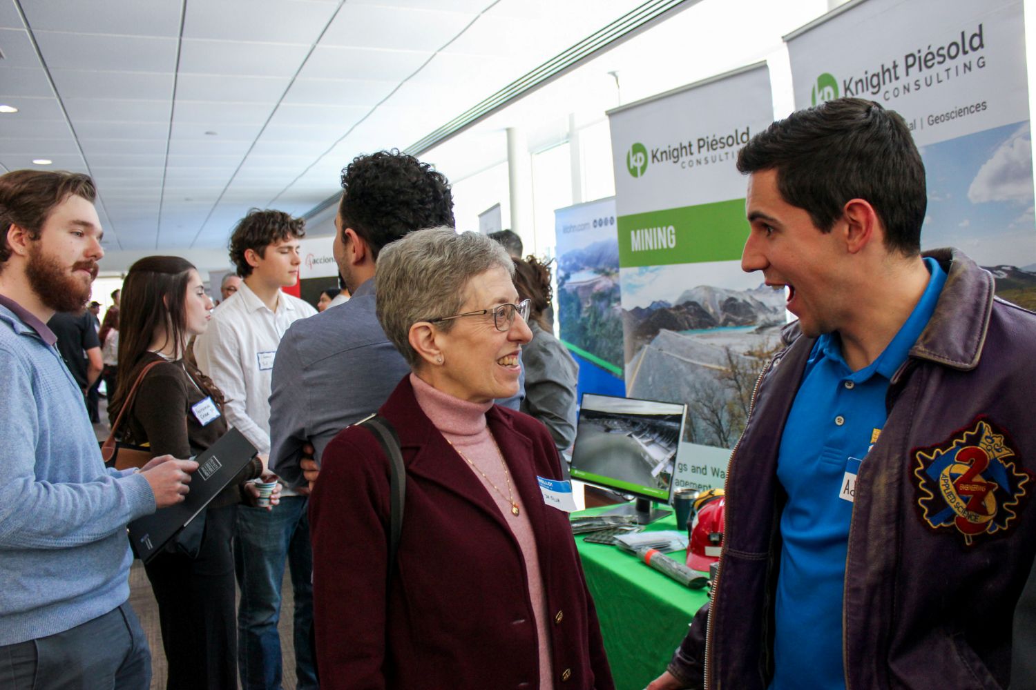 Woman and man speak to each other enthusiastically at a trade show
