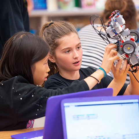 Two children working on a robot