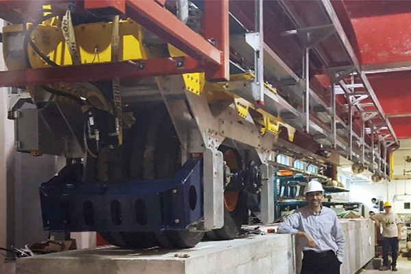 A researcher tests a full-scale bridge girder using the Rolling Load Simulator (ROLLS)
