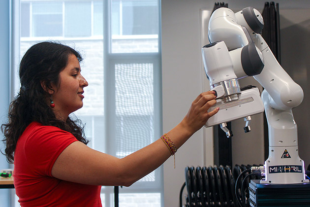 female researcher in profile looking at a peice of equipment