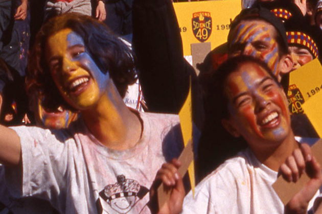 crowd of students in facepaint behind barrier at Homecoming