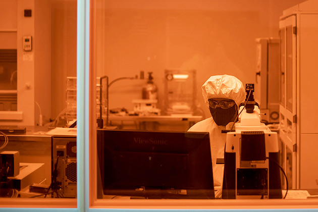 man in protective gear in an enclosed room with reddish lights