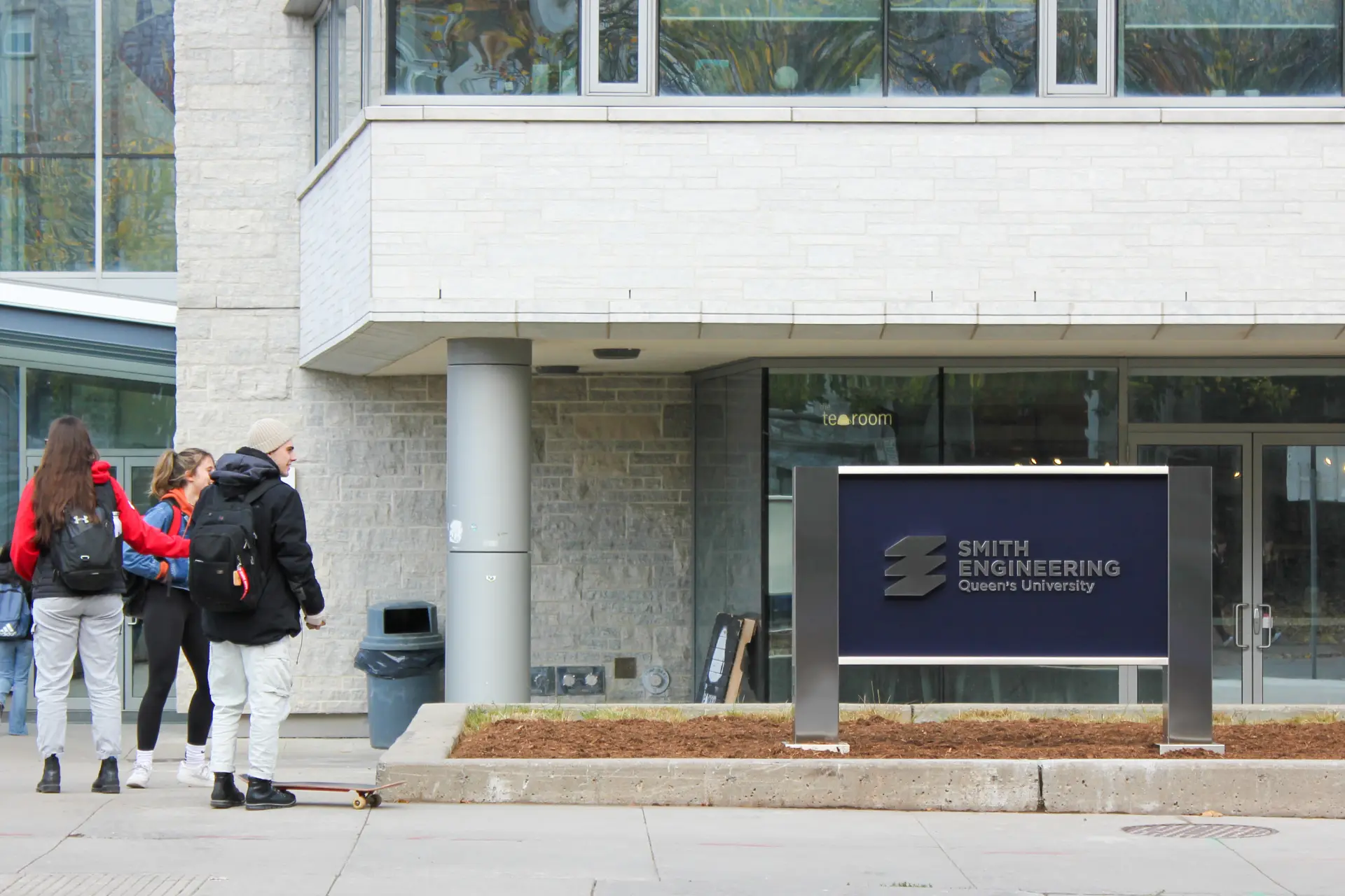 students looking at the Smith Engineering sign